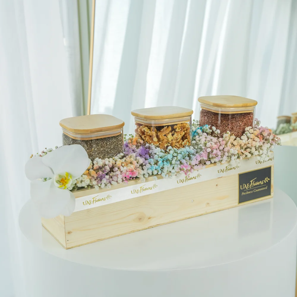 Collection of white cymbidium orchid, Chia seeds, Walnuts, Flax seeds and pastel colored baby's breath around the wooden box.