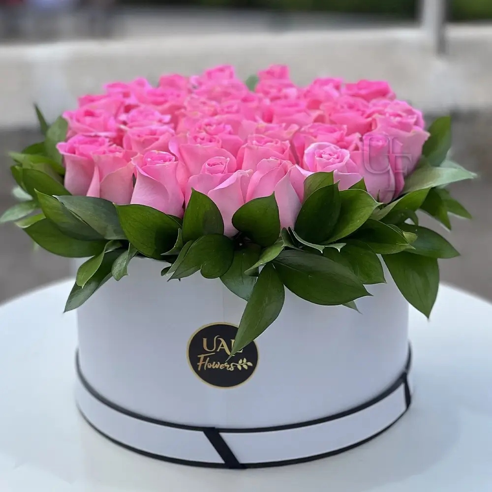 60 pink roses with green fillers arranged in a white round box