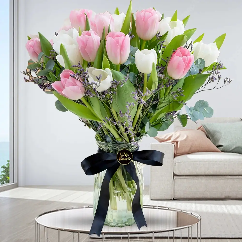 20 pink and white tulips with greens fillers in a glass vase