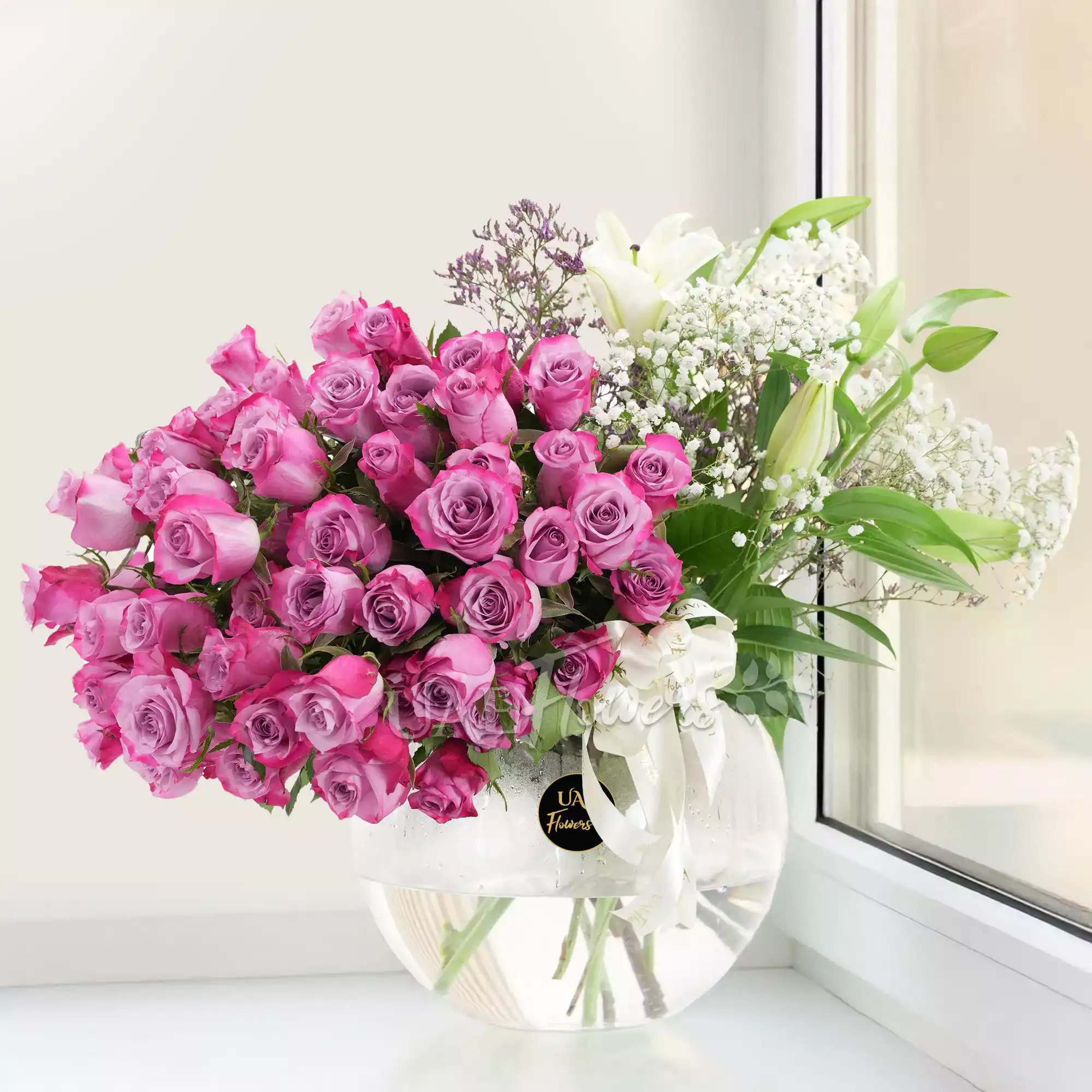 50 purple roses and 2 white lilies in a vase