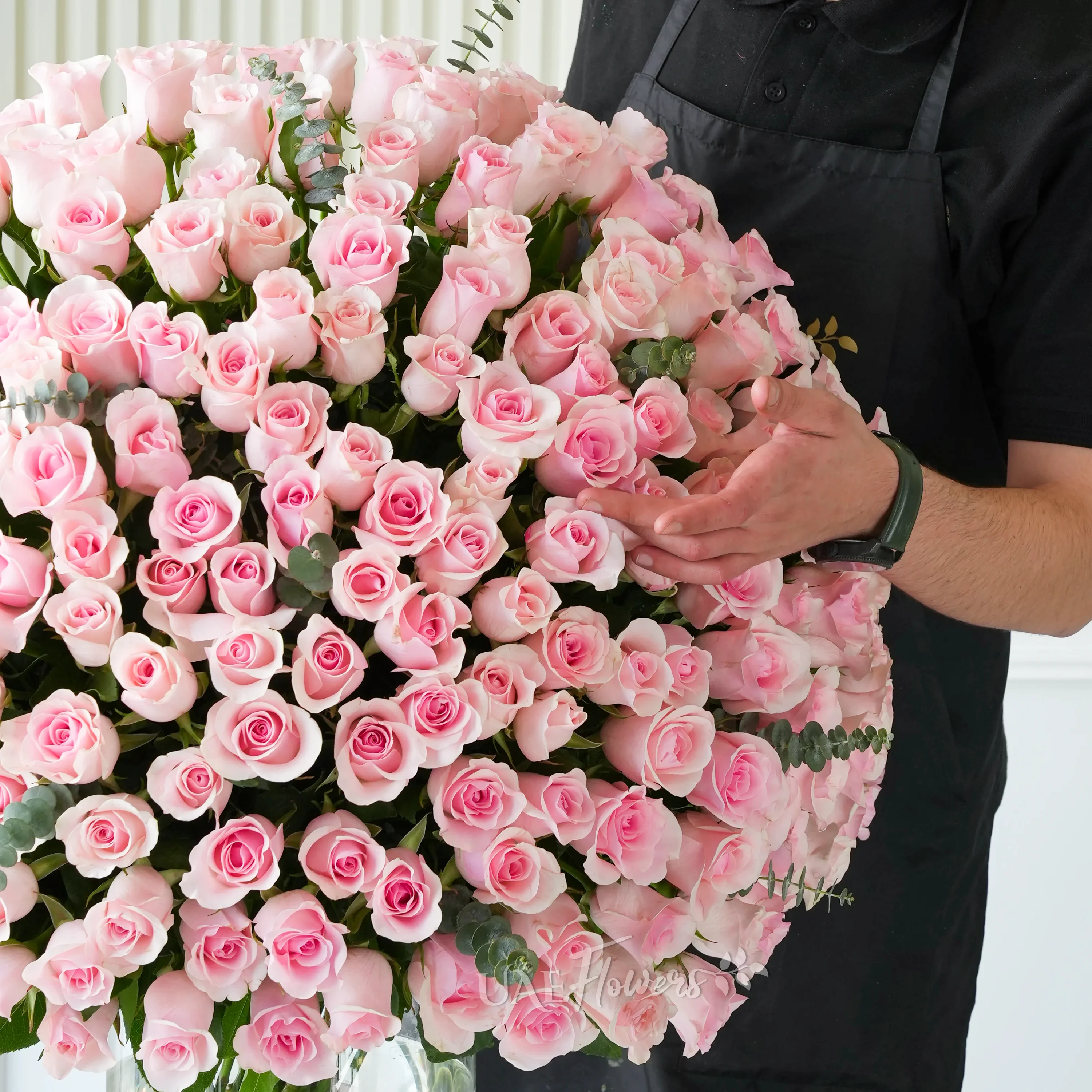 Elegant vase filled with 200 vibrant pink roses and lush green fillers, perfect for grand celebrations.
