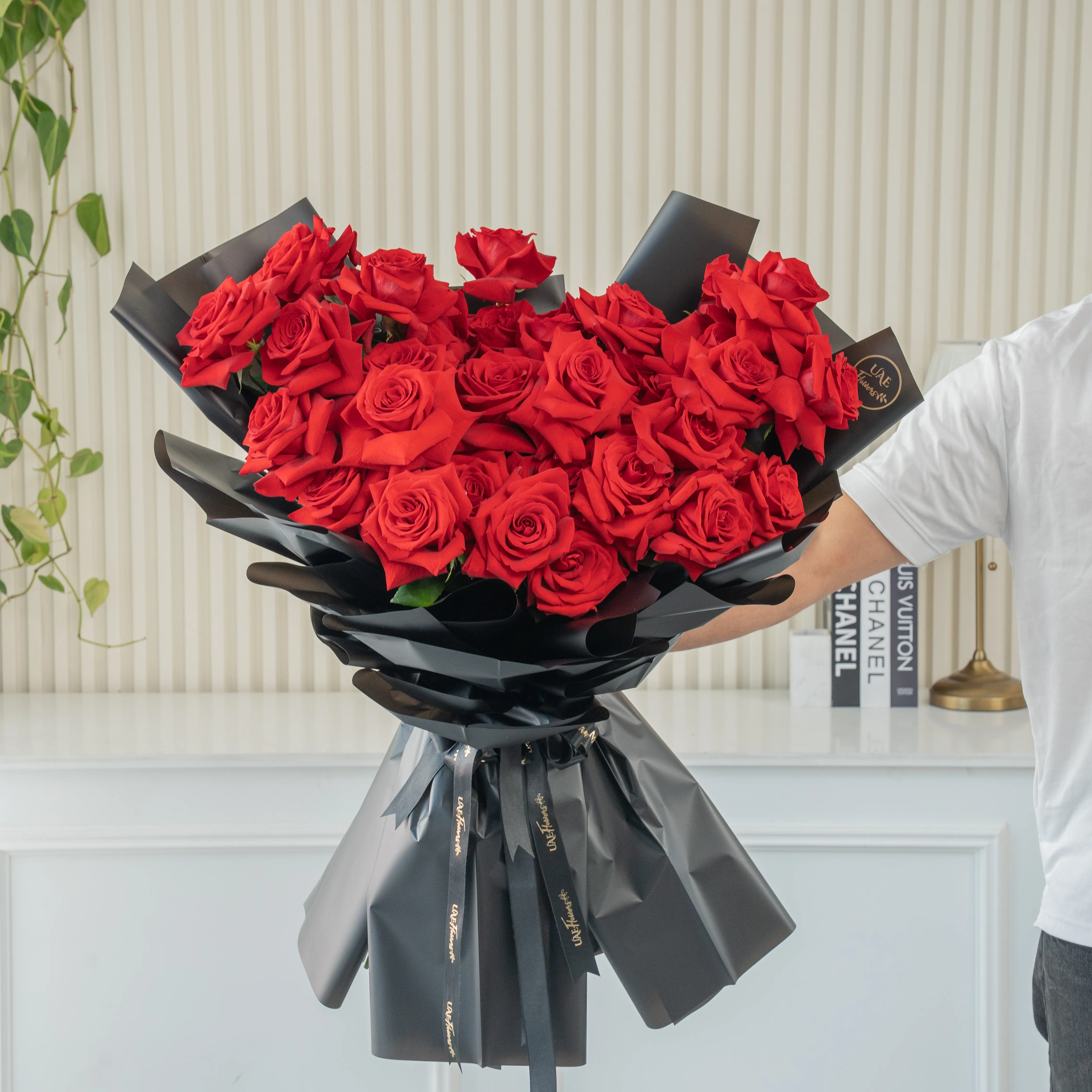 Bouquet of 25 red roses in black paper packing
