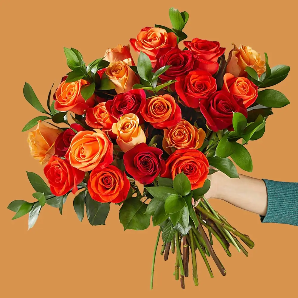 A bouquet of 25 red, orange & peach roses with green fillers tied with ribbon A bouquet of 25 red, orange & peach roses with green fillers tied with ribbon