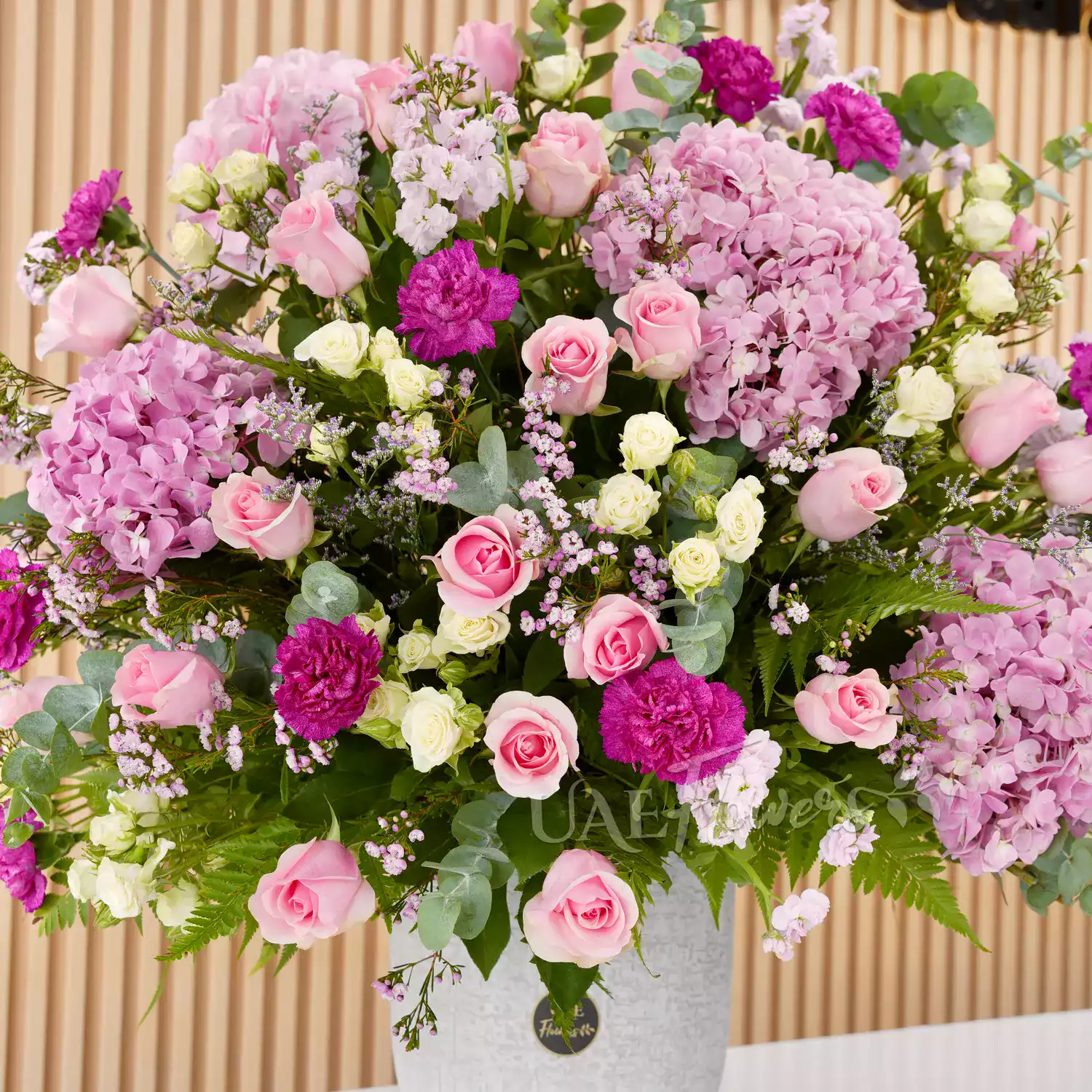4 pink hydrangeas, 20 pink roses, 5 pink matthiola, and 7 green lisianthus with green fillers in a glass vase