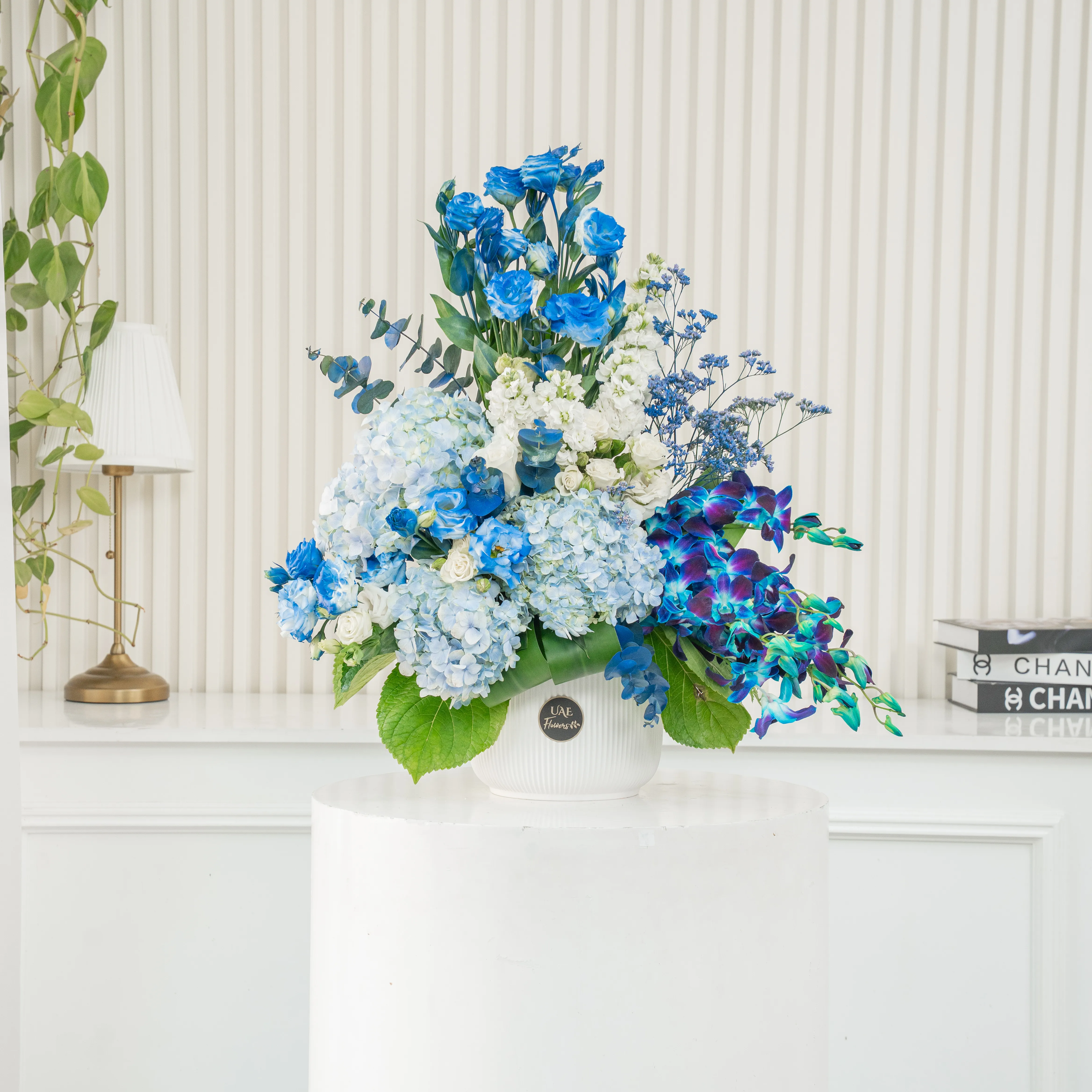 Serene ceramic pot arrangement of white blooms and blue orchids, hydrangeas, and fillers