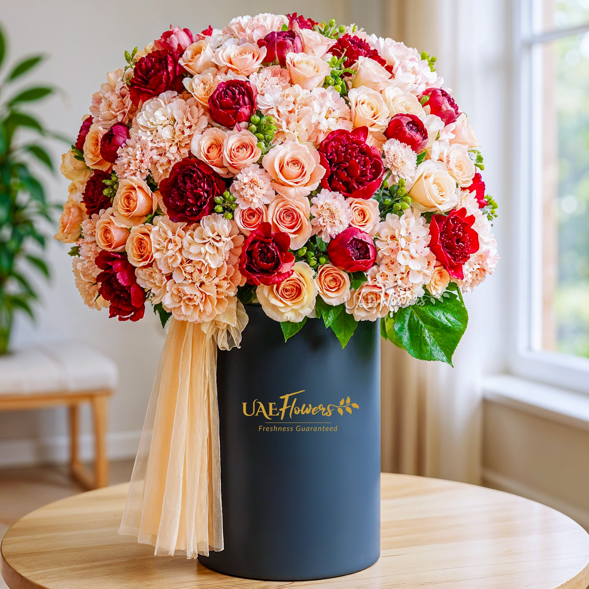 Tall round box with 20 pink hydrangeas, 20 red roses, 40 peach roses, 40 light pink carnations, and green hypericums.