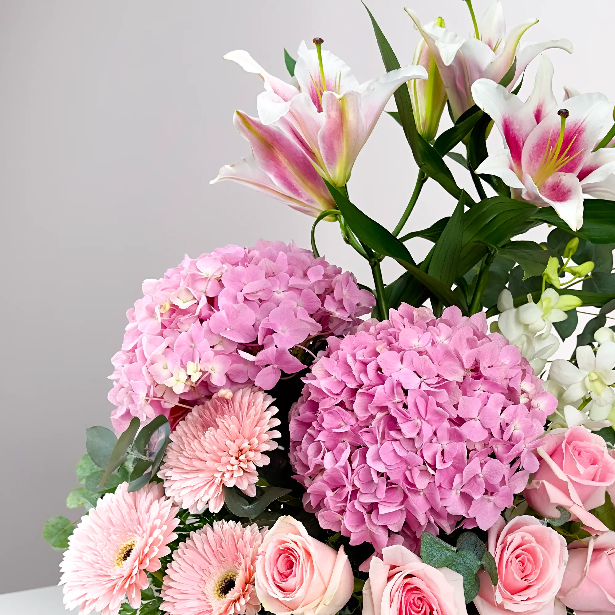 2 pink hydrangeas, 2 pink lilies, 10 pink roses, 3 pink gerberas, and 5 white orchids