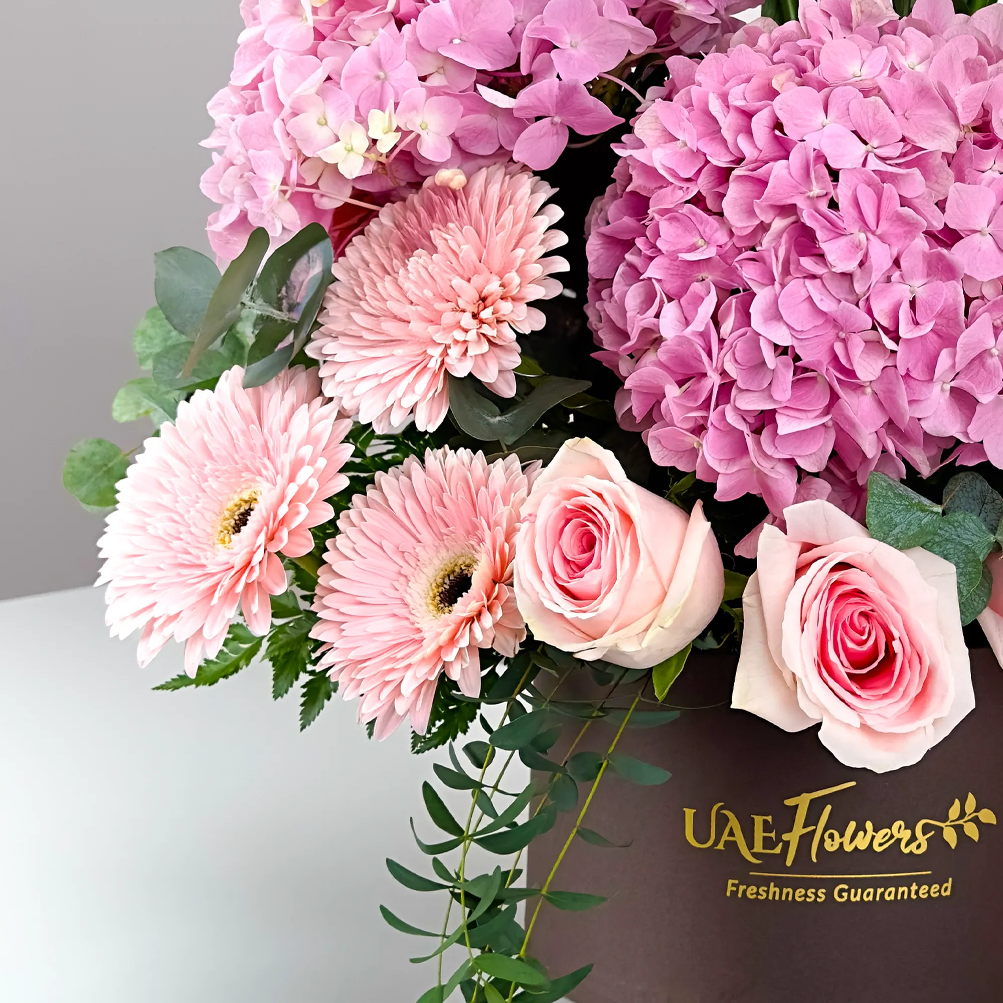 2 pink hydrangeas, 2 pink lilies, 10 pink roses, 3 pink gerberas, and 5 white orchids