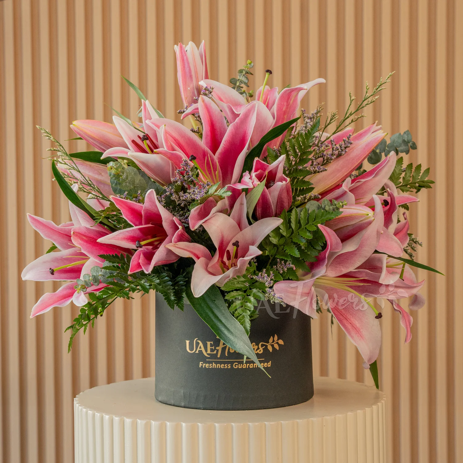 5 pink lilies with eucalyptus leaf and limonium fillers in a black round box