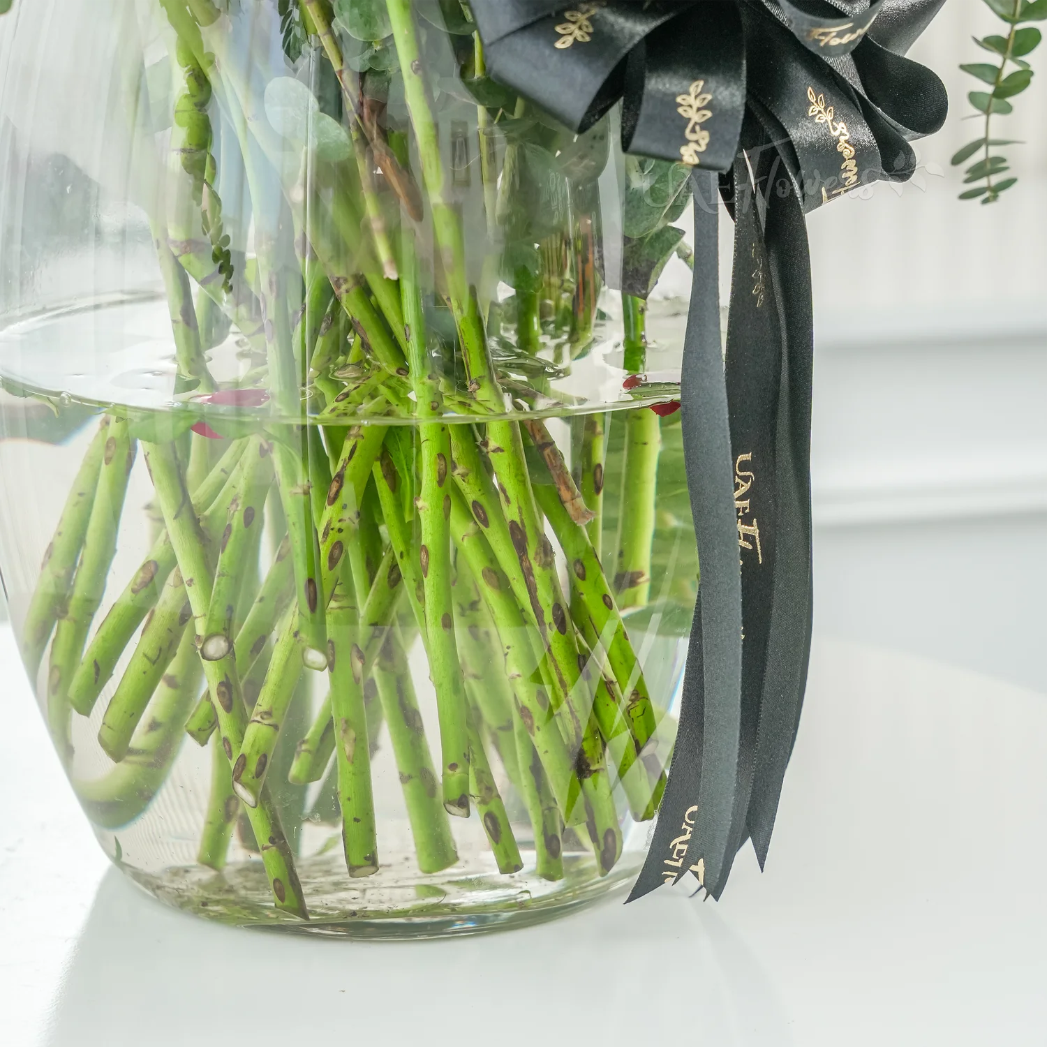 40 red spray roses with eucalyptus in a glass vase.