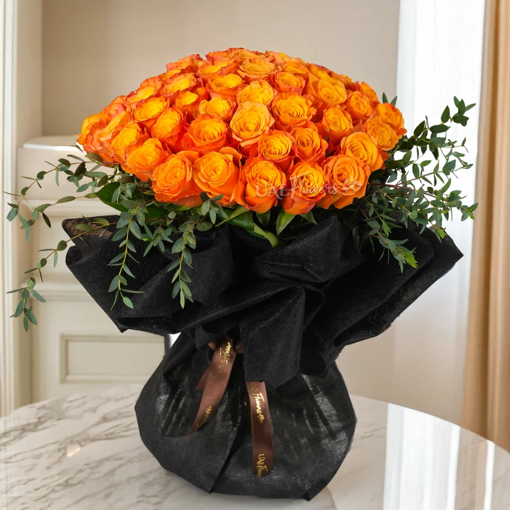 bouquet of 40 orange roses with green fillers, wrapped in black paper